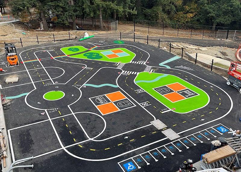 a paved area has a play area road 和 parking painted on it