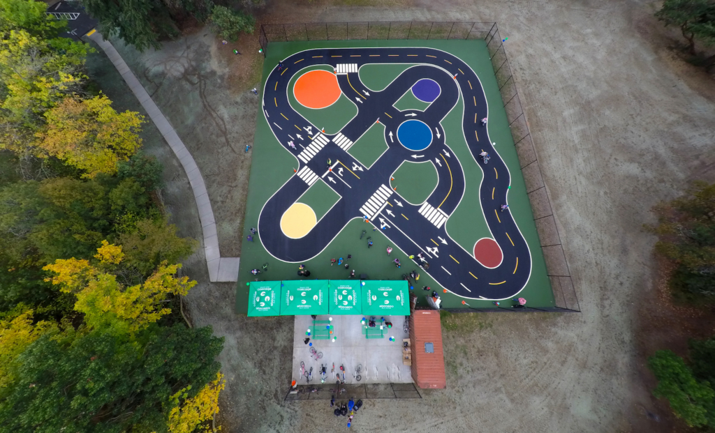 aerial view of miniature streets 和 traffic circles painted onto asphalt surface.
